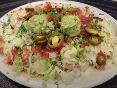 Los Nachos Gordos (The Fat Nachos) are a Big Portion of Corn Tortilla Chips with Melted Cheese, and Choice of Beef or Chicken, Served with Sliced Jalapeños, Guacamole, Sour Cream, Lettuces, Diced Onions and Tomatoes