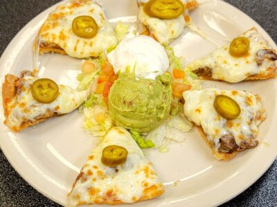 Bistec Nachos (Steak Nachos) are Delicious Nacho chips with Tender Strips of Beef, accompanied with Beans, Cheese, Guacamole, Sour Cream, Sliced Jalapeños, Lettuce, and Diced Tomatoes and Onions. OLE Flaco's Steak house and Mexican Restaurant
