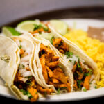 Tacos al Pastor are 3 Marinated Pork and Pinnapple Corn Tortilla Tacos, served with Rice and Refried Beans. Make substitutes below. OLE Flaco's. Mexican Restaurant of Naples